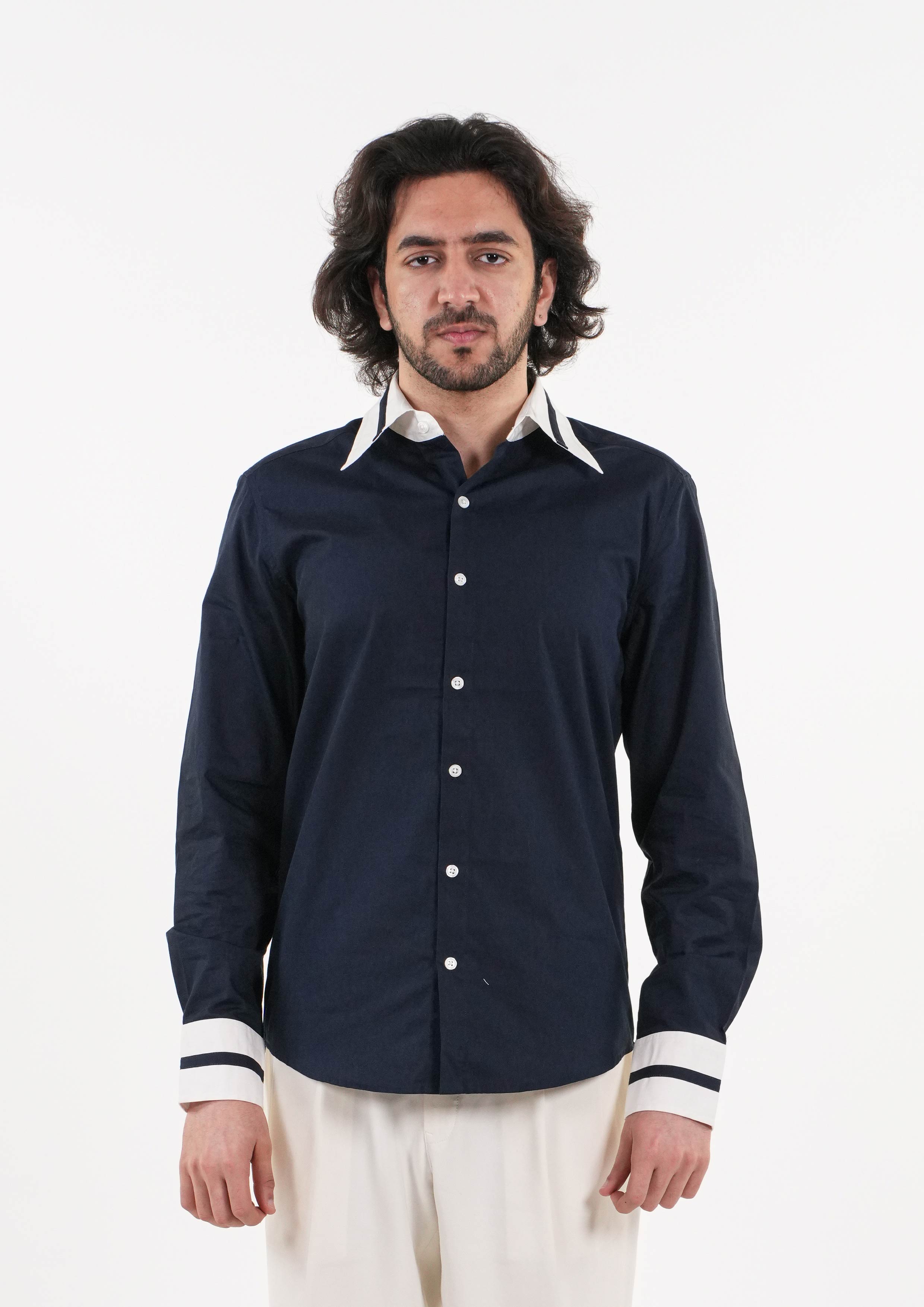 Man wearing a navy blue shirt with white trim on a white background