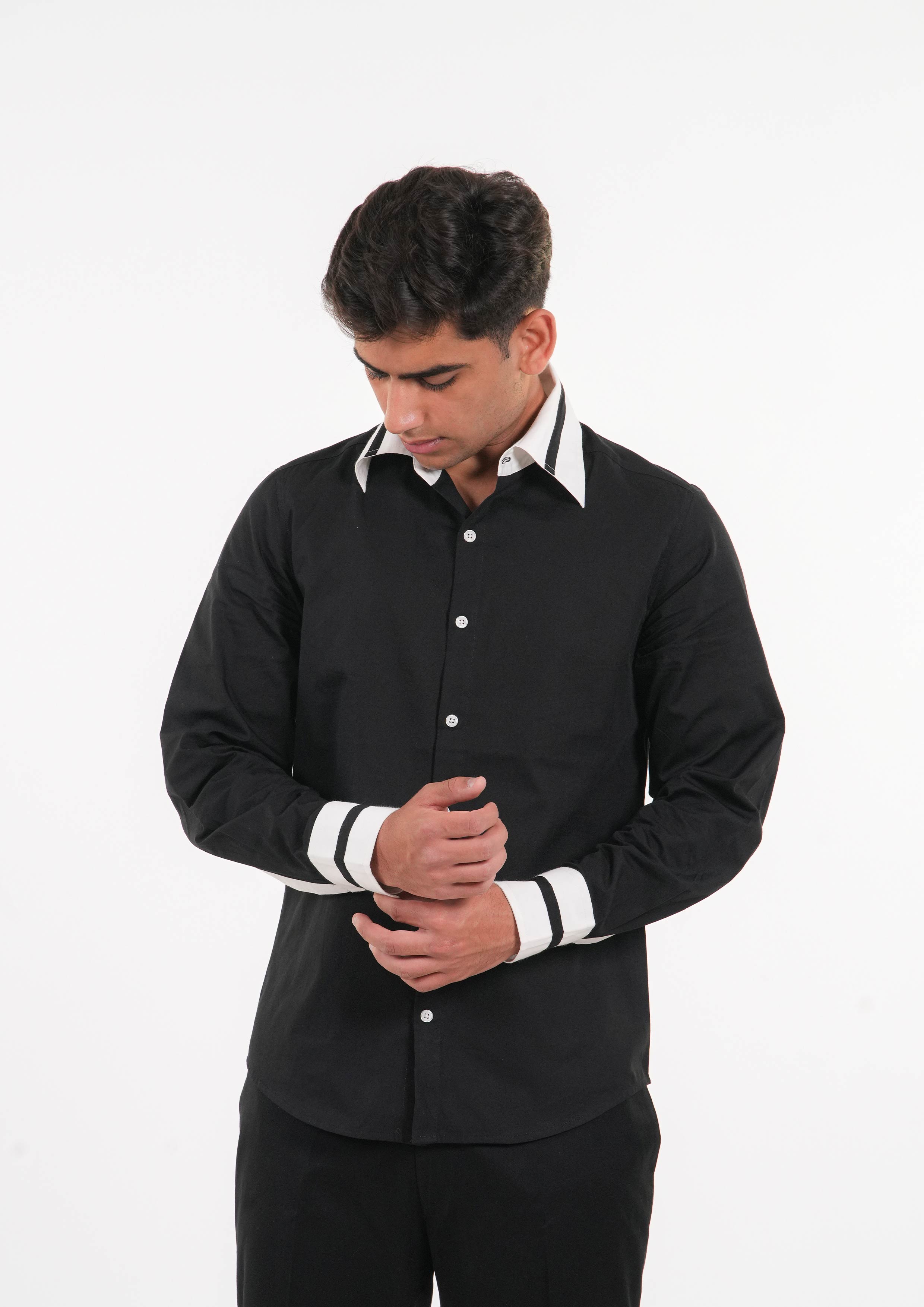 Man wearing a black shirt with white trim on a white background